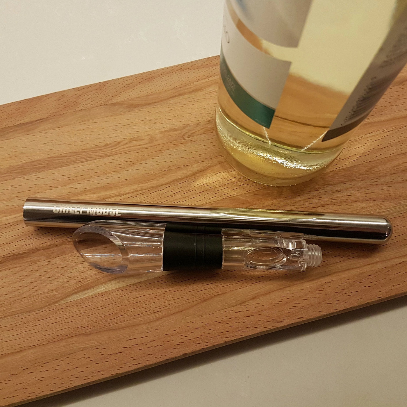 The Chilly Wine Icicle disassembled on a cutting board beside a bottle of white wine.