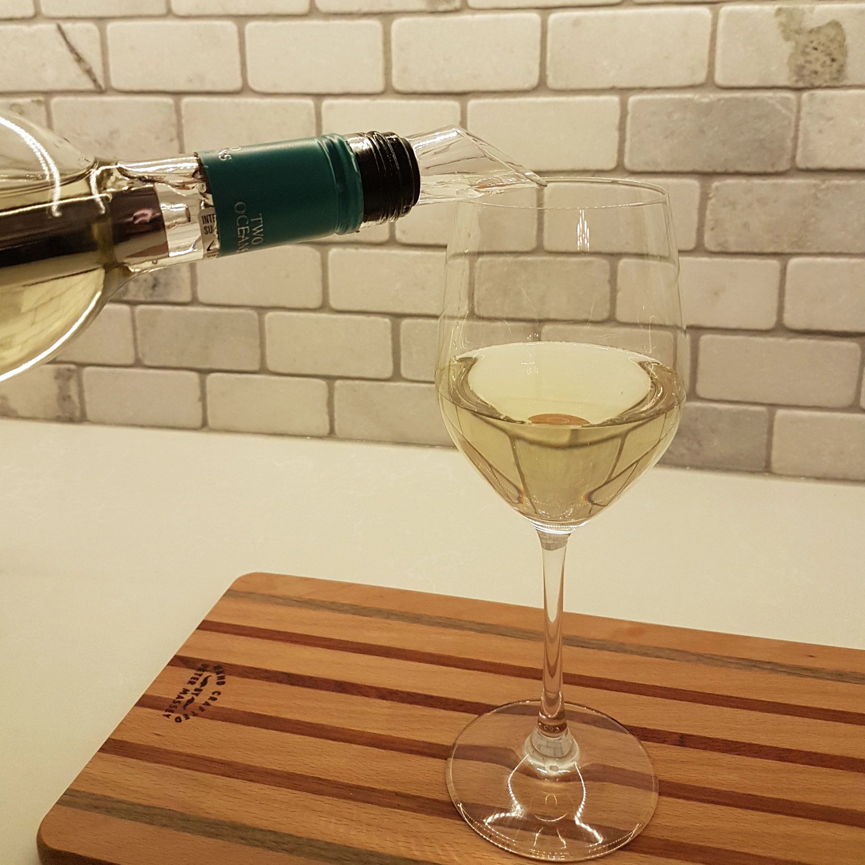 White wine being poured into a glass using the Chilly Wine Icicle.